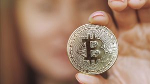 Anonyme Frau mit Bitcoin-Münze